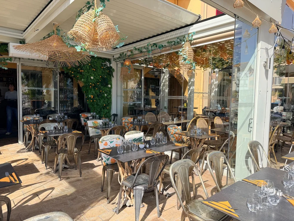 Les tables dressées sous la pergola, au soleil